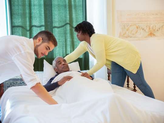 Vårdpersonal hjälper en sängbunden patient