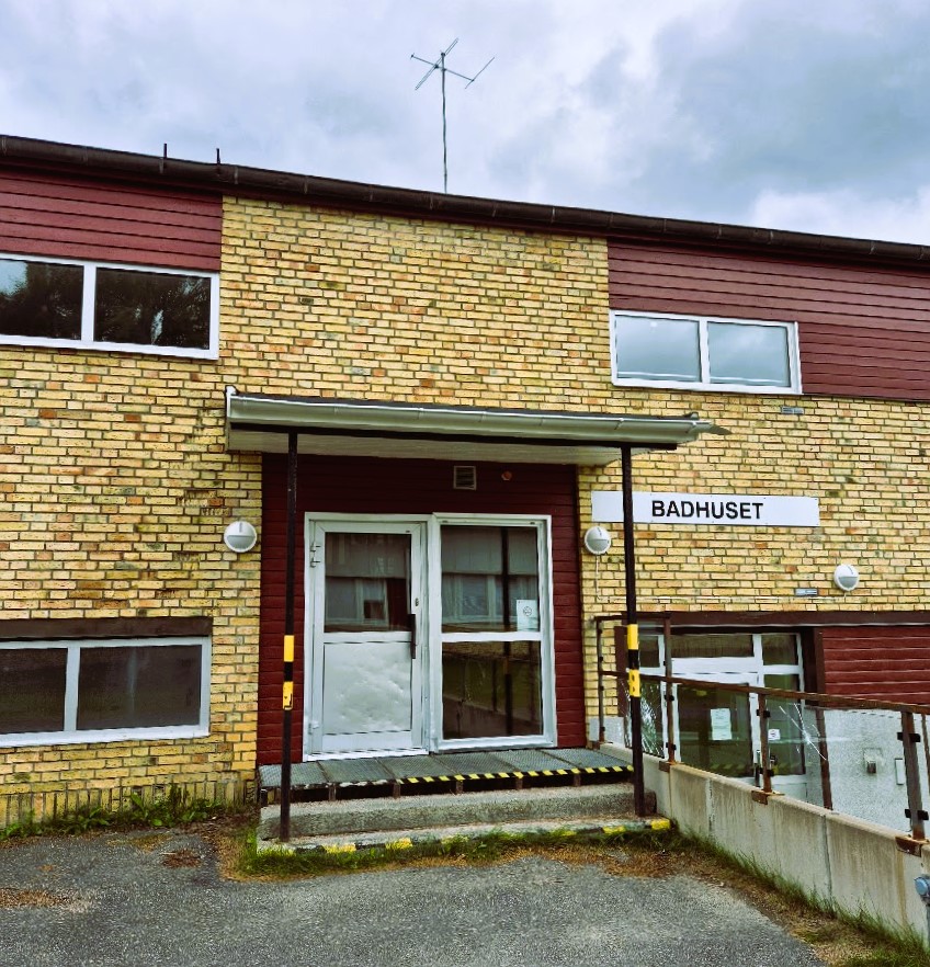 entré till badhuset, gul tegelbyggnad med dörr och fönster