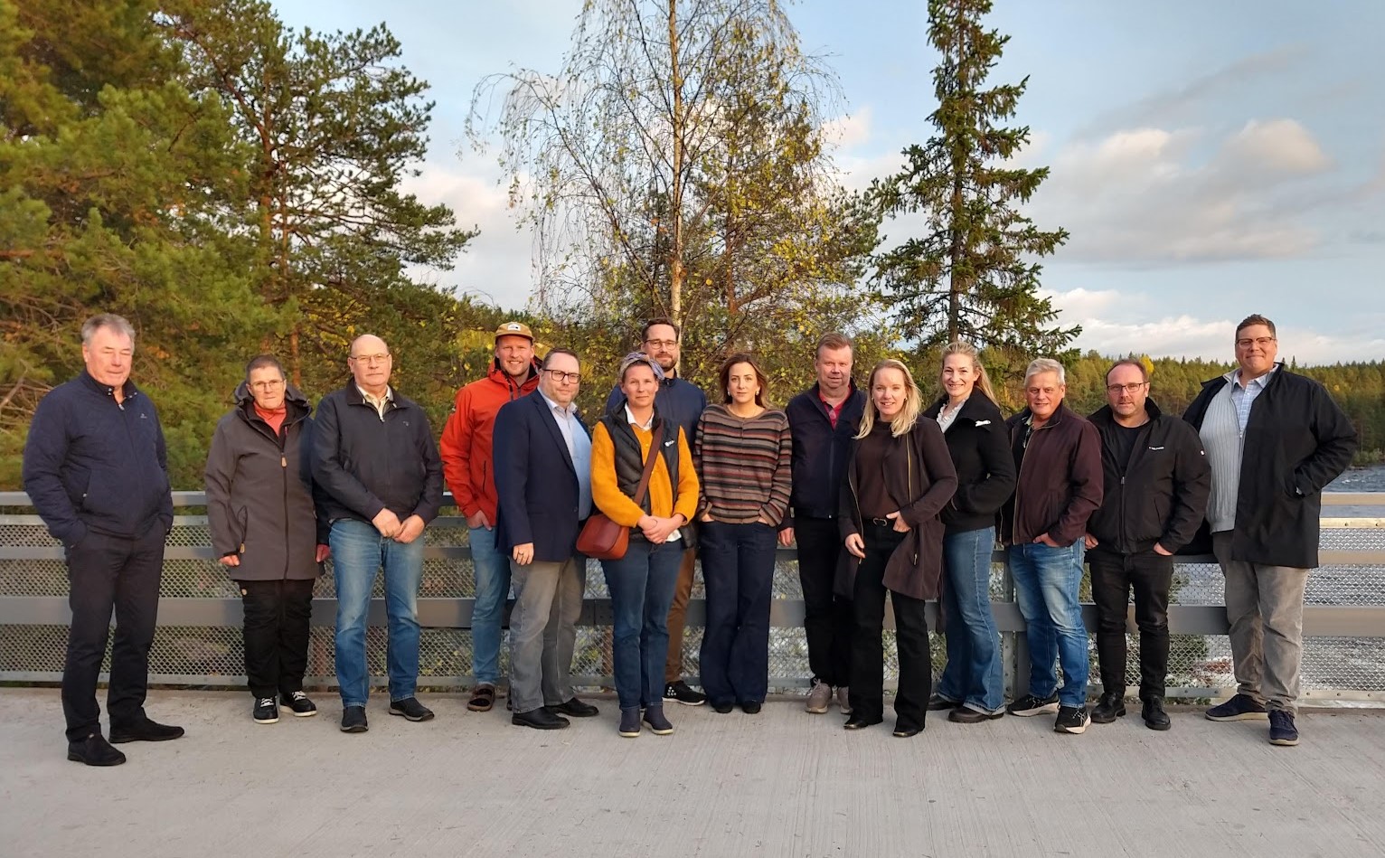 ett antal personer står utomhus tillsammans för en gruppbild