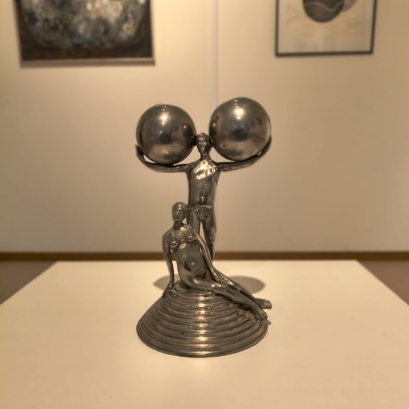 Skulptur i metall förställande två personer. 