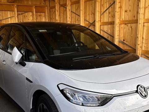 bilden visar en vit elbil i en carport