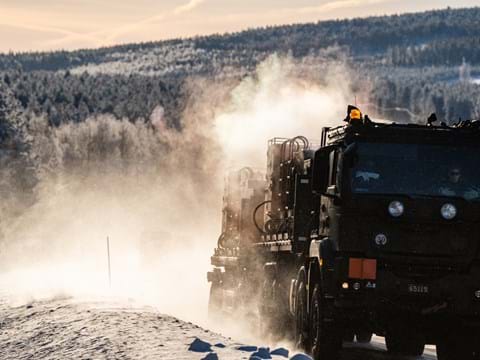 militärfordon körs på snöig väg