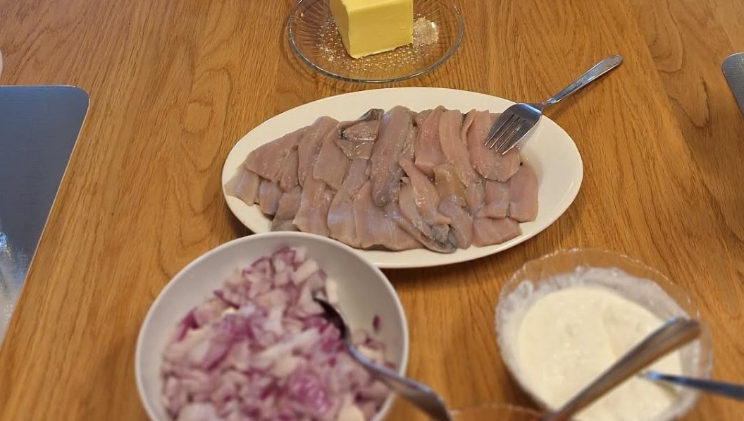 surströmming och tillbehör uppdukade på bord