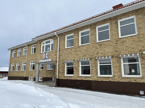 Bilden visar en gul tegelbyggnad kallad BIC-huset som ligger på Överkalix skolområde.