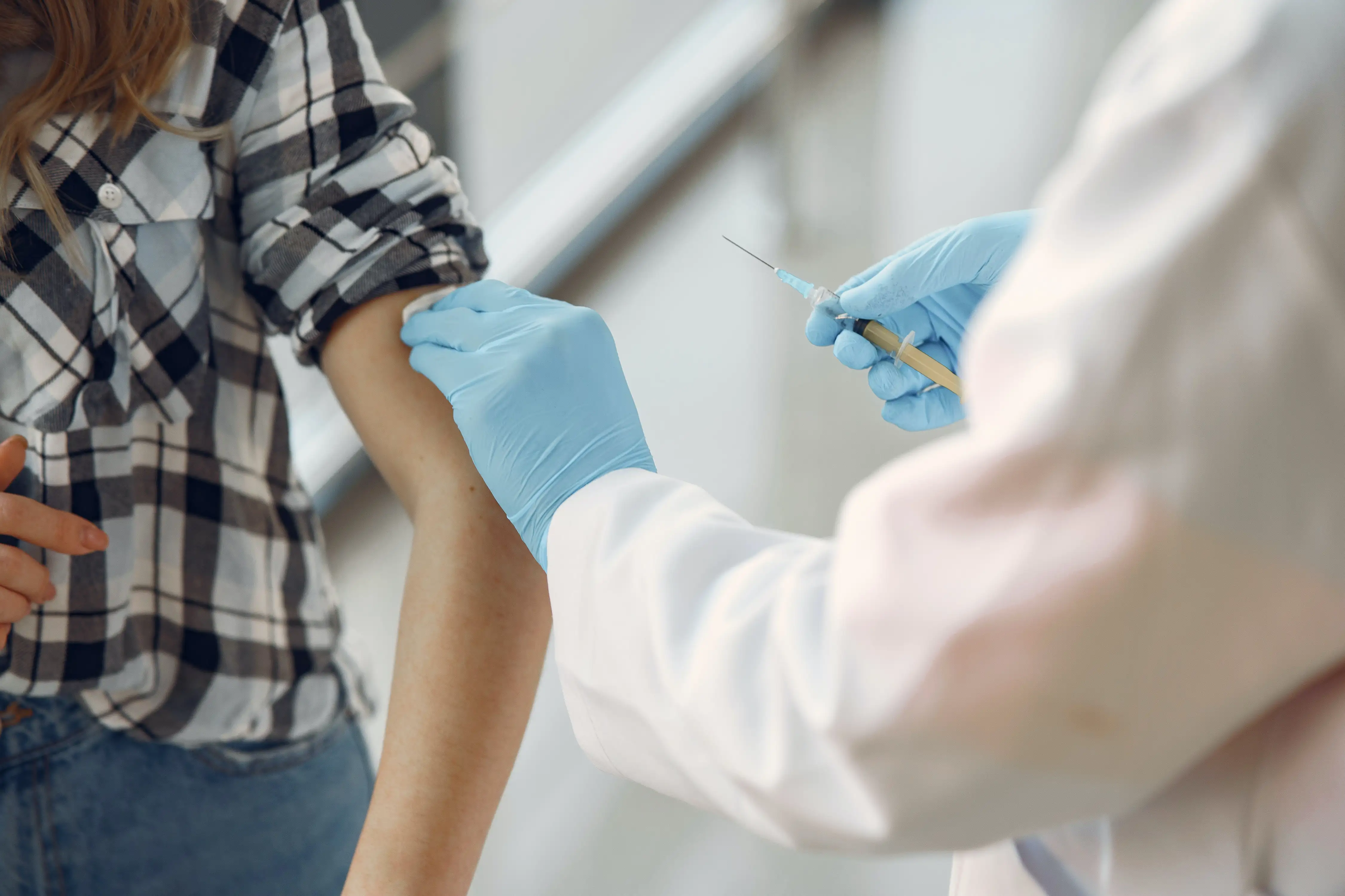en person får en vaccintationsspruta i armen av sjukvårdspersonal