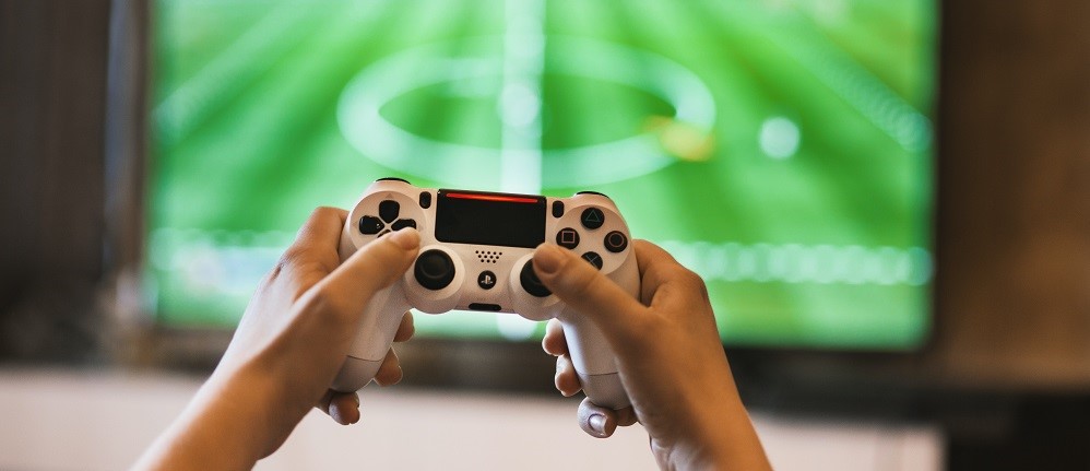 Bild av händer som håller en spelkonsoll.