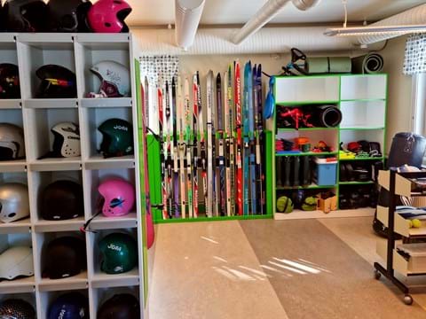 bilden visar ett rum med idrottsutrustning som slalomhjälmar och skidor.