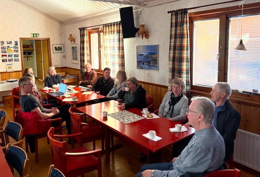 människor sitter vid bord och fikar och samtalar