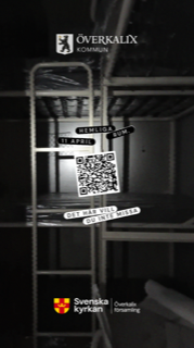 ett mörkt rum där en stege till en våningssäng syns, på bilden en qr-kod